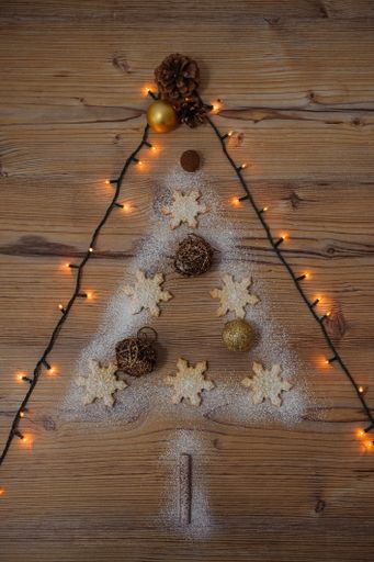 A vertical shot of a Christmas tree made of cookies and decorations and surrounded by lights