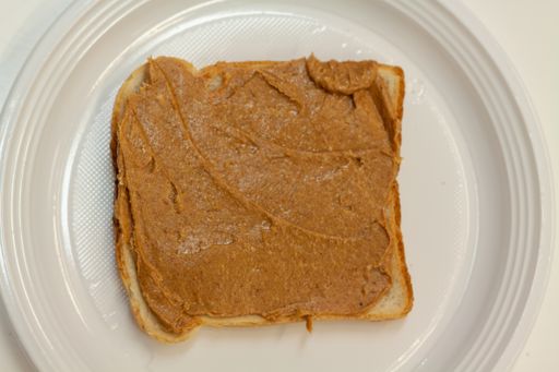 A vertical shot of peanut butter on a toasted bread