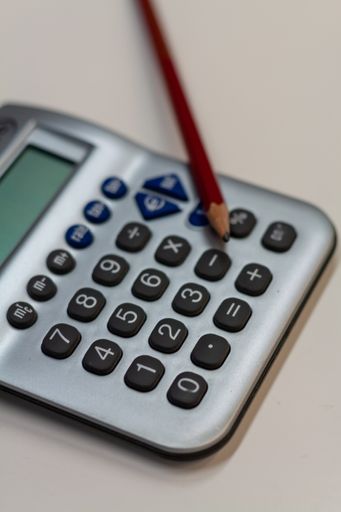 A vertical closeup shot of a calculator and a pencil