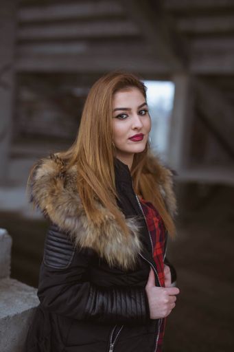 A vertical shot of a white Caucasian woman wearing a black jacket and posing for a picture