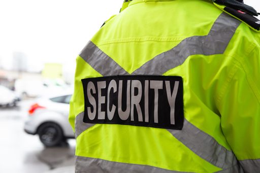 A closeup shot of a back of security guard watching over a parking area