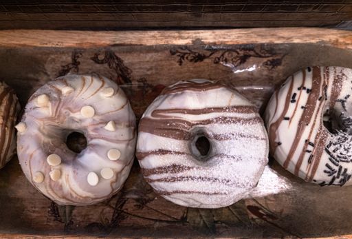 A closeup shot of a variety of donuts on wooden trays