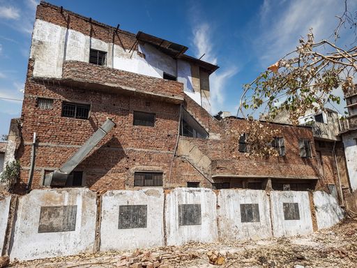 A scenery of an abandoned building under the cloudy sky