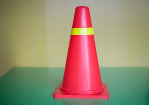 A closeup shot of a red traffic cone on a blurred background