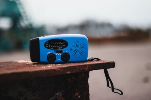 A selective focus shot of a small handy radio on an old wooden table