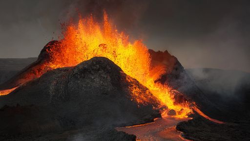 A dramatic shot of an erupting volcano, surrounded by a cloudy sky