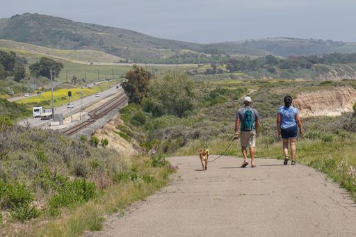 Two walkers and their dog follow the Aniso Trail along the Santa Barbara County Coast near Refugio State Beach.