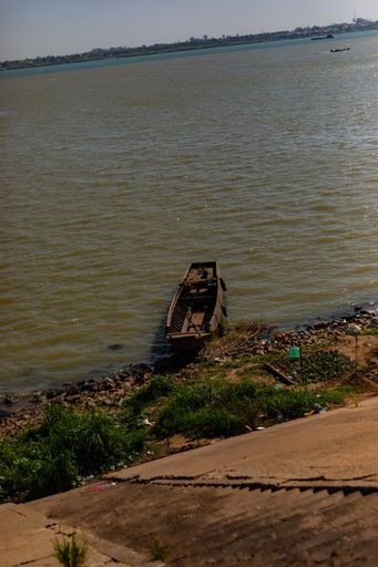 An old wooden rustic boat moored in the bank of a river in Phnom Penh, Cambodia