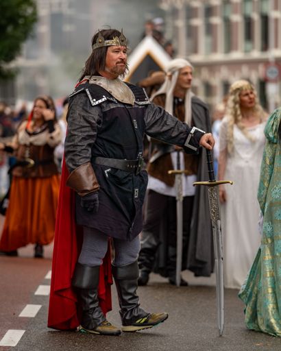 A Caucasian man in a medieval costume marching at a parade in Leiden, Netherlands