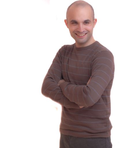 A young bald man smiling with his arms crossed isolated on a white background