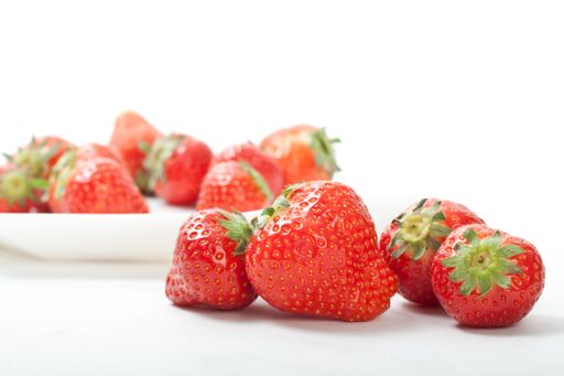 A selective shot of fresh strawberries on a white background