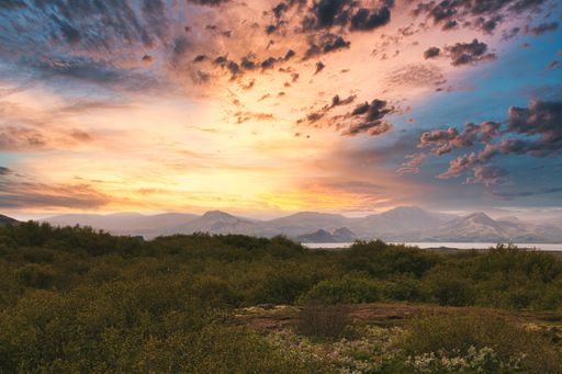 A mesmerizing view of the fields and mountains captured during a breathtaking sunset