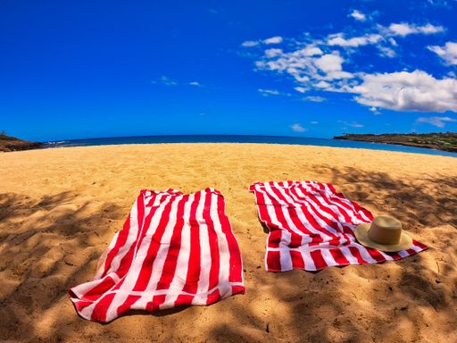 Two red and white striped towels at the beach