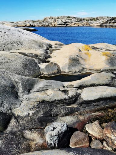 A scenic shot of a sea surrounded by stone mountains in Verdens Ende, Norway