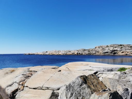 A scenic shot of a sea surrounded by stone mountains in Verdens Ende, Norway