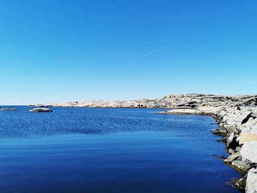 A scenic shot of a sea surrounded by stone mountains in Verdens Ende, Norway