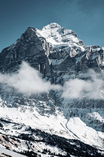A beautiful shot of the snowy mountains surrounded by clouds