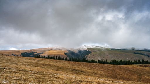 The Tian Shan Mountains in Xinjiang on a gloomy day with dark clouds covering the sky