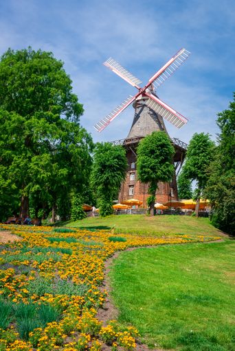 A vertical shot of a historic windmill in Wallanlagen Park, Bremen, Germany