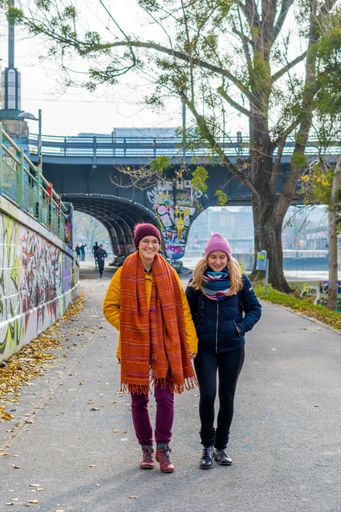 The two female friends holding hands while walking in the park, Austria