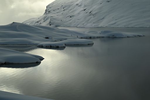A majestic shot of layers of snow over a frozen lake in Switzerland between Morterasch and Poschiavo