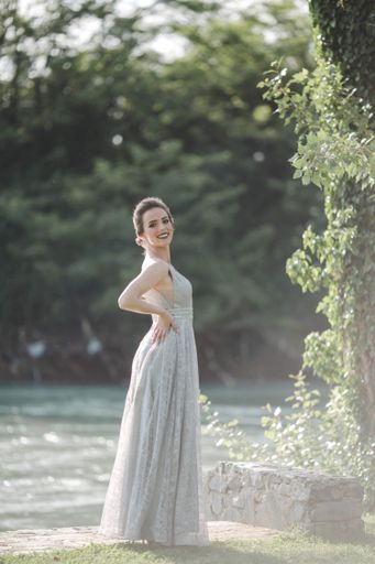 A shallow focus of an adult woman wearing a long gray dress in a park in Bosnia and Herzegovina