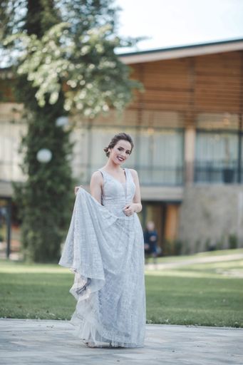 A young attractive Caucasian female with makeup wearing a beautiful evening gown and posing outdoors