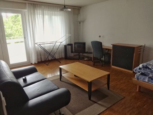 View of a nicely arranged Living room of an apartment with a door to enter balcony