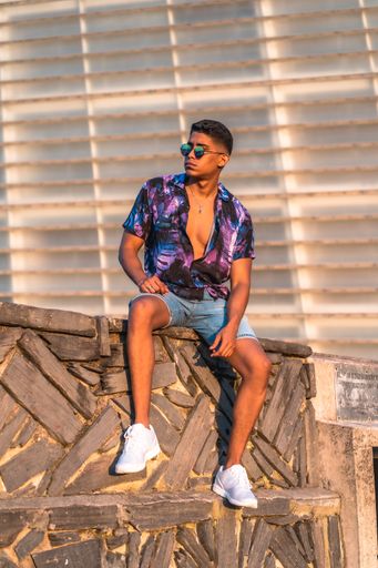 A vertical shot of a Hispanic male enjoying summer sitting on a border