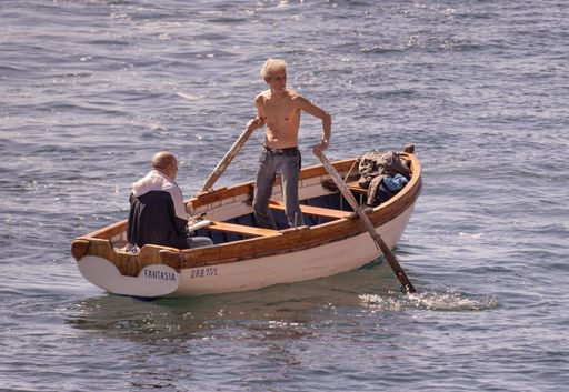 Man sailing in a small wooden boat in Naples, Italy, May 31th 2021.