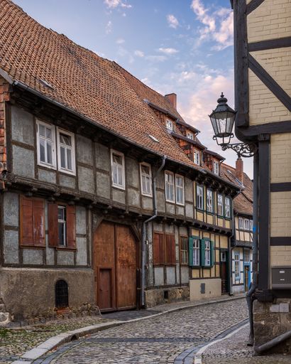 A cobblestone street with historic buildings in Quedlinburg, Germany
