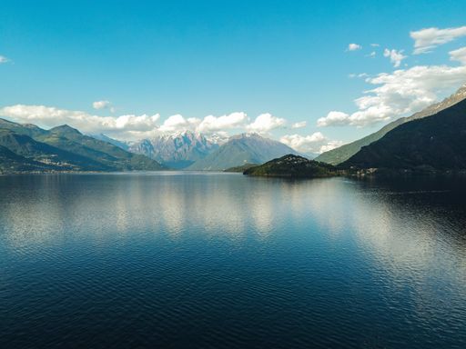 A beautiful scenery of a calm lake surrounded by hills under the cloudy sky