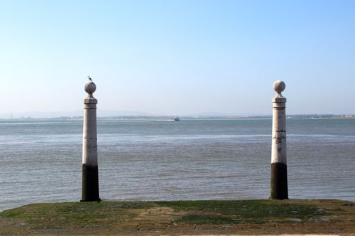 A scenic view of two pillars by the ocean in Lisbon, Portugal