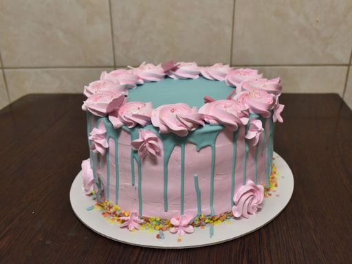 A high angle shot of a birthday cake with pink flowers and butterflies dressing
