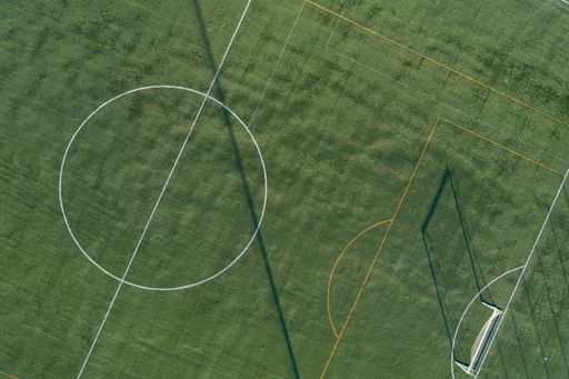 Drone aerial view of an artificial grass soccer field at sunset