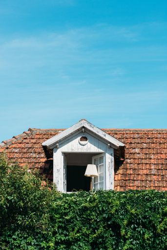 A vertical shot of a white attic with an opened window in Cascais, Portugal