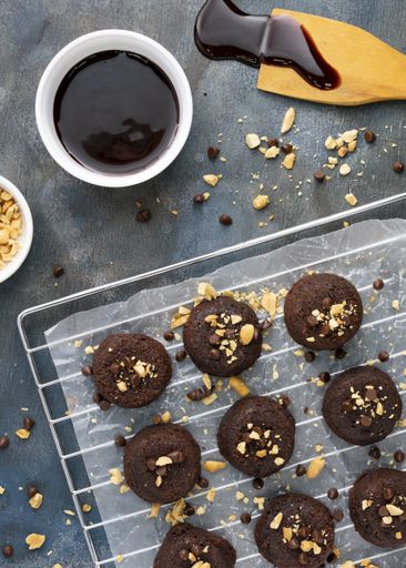A vertical top view of deliciously baked chocolate lava cakes sprinkled with nuts and icing on a grid