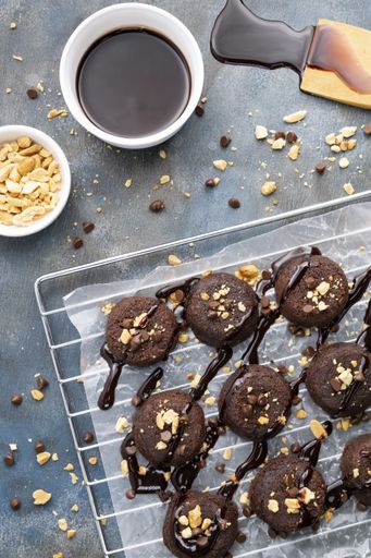 A vertical top view of deliciously baked chocolate lava cakes sprinkled with nuts and icing on a grid