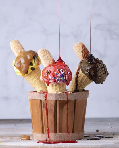 A vertical shot of ice cream of different flavors in waffle cones