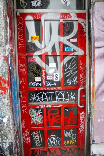 A vibrant red door with graffiti artwork covering the surface in New York, United States