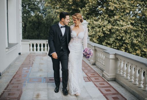 A happy bride and groom having fun and walking on a balcony