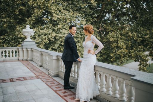 A happy bride and groom on a balcony posing for the wedding photoshoot