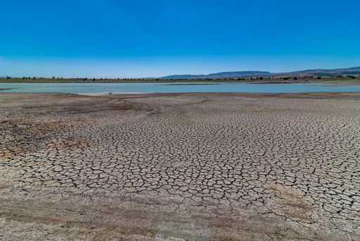 A horizontal shot of a drained lake in a dry arid area