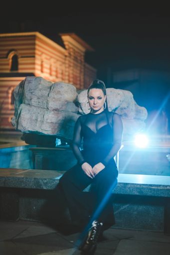 A vertical shot of a white Caucasian woman wearing classic black clothes and posing for a picture