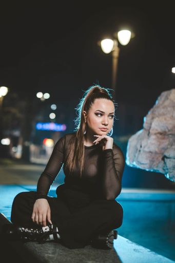 A vertical shot of a white Caucasian woman wearing classic black clothes and posing for a picture