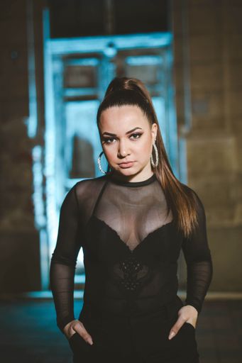 A vertical shot of a sexy Caucasian female posing against the door