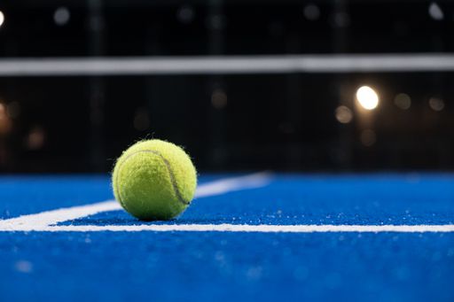 ball on a paddle tennis court at night, racket sport court