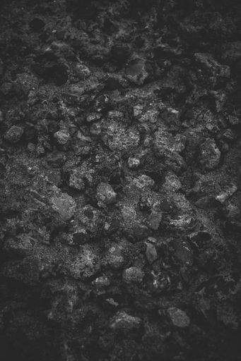 Closeup of dark rock textured background. Gray rough stone texture and background for design. Black abstract background made with stone.