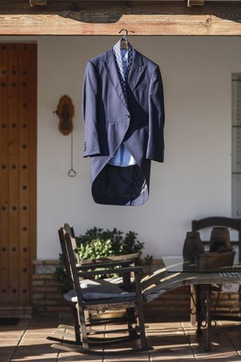 A vertical shot of the groom's suit hanging outdoor