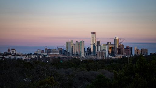 An aerial view of the beautiful skyline of Downtown Austin, Texas illuminated by the golden sunset